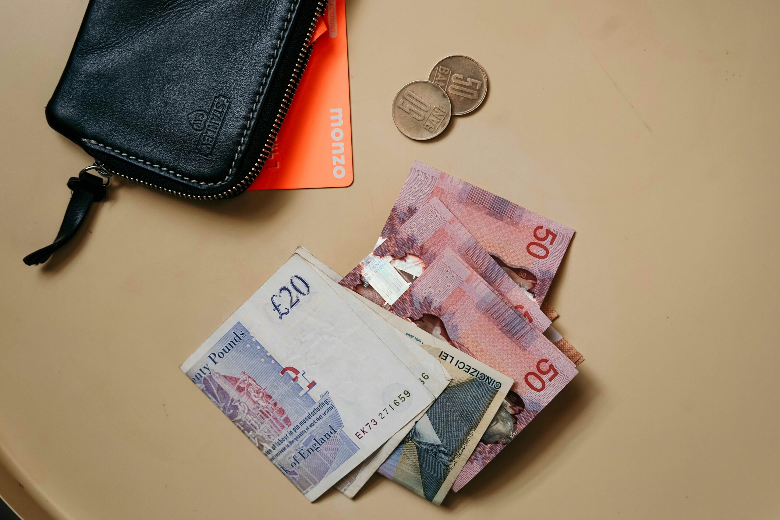 cash and wallet with Monzo debit card visible, on a table